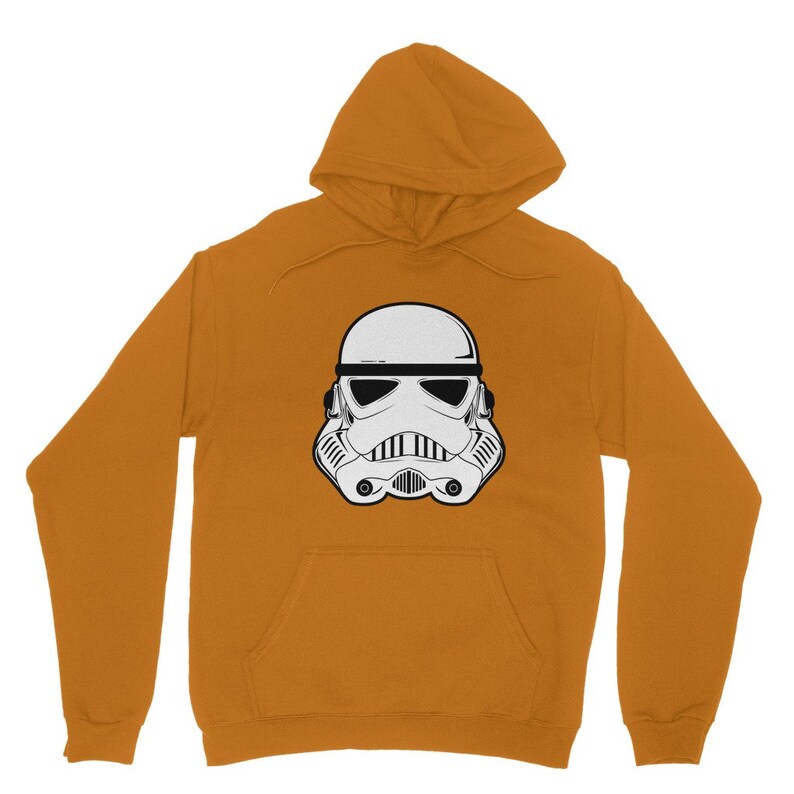 Puede incluir: Una sudadera con capucha de color amarillo mostaza con un gr&aacute;fico blanco y negro de un casco de Stormtrooper.