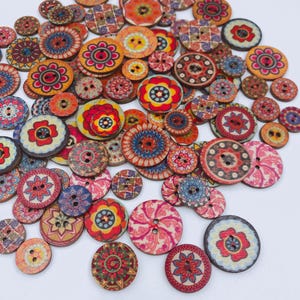 Puede incluir: Una colección de botones redondos de madera con una variedad de patrones florales y geométricos coloridos e intrincados. Cada botón tiene dos o cuatro agujeros en el centro, con diseños en tonos de rojo, naranja, amarillo, azul y rosa.
