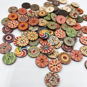 Puede incluir: Una gran colección de botones redondos de madera con una variedad de patrones impresos coloridos, que incluyen diseños florales, geométricos y de remolinos. Cada botón tiene dos agujeros en el centro y una superficie plana con acabado mate.