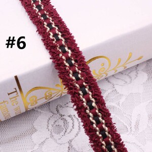 May include: Burgundy trim with black and gold accents. The trim has a fuzzy texture and is perfect for adding a touch of elegance to any project.