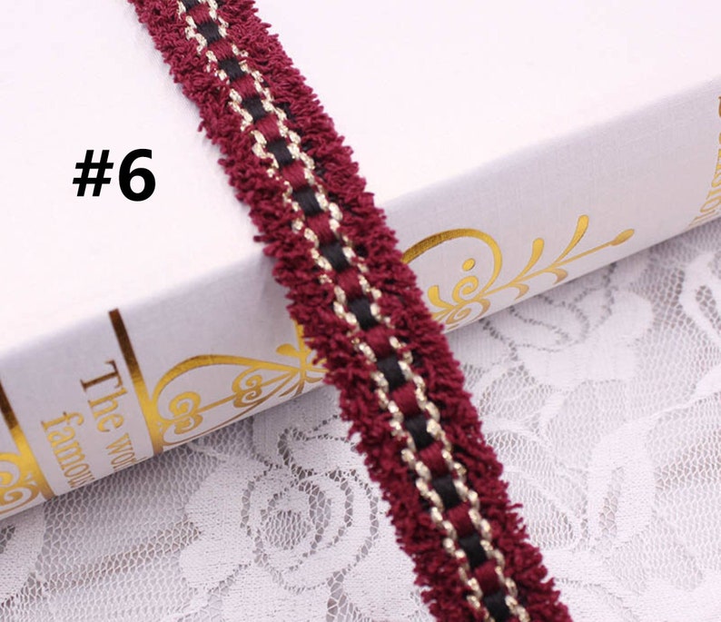 May include: Burgundy trim with black and gold accents. The trim has a fuzzy texture and is perfect for adding a touch of elegance to any project.