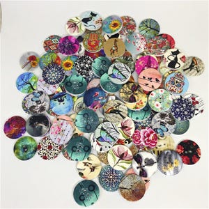 May include: A large collection of circular wooden buttons featuring a variety of printed designs including flowers, animals, butterflies, geometric patterns, and abstract art. Each button has two or four holes for sewing, with diverse colors.