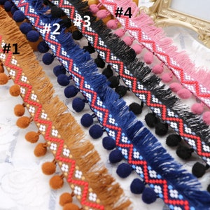 Puede incluir: Cinco diferentes galones con pompones y flecos. Los galones son de color marrón, azul marino, negro, rosa y blanco con patrones geométricos rojos y blancos. Los galones están etiquetados como #1, #2, #3, #4.