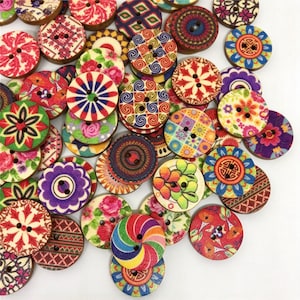 Puede incluir: Una colección de botones redondos de madera con una variedad de patrones impresos coloridos, incluyendo diseños florales, geométricos y en espiral. Cada botón tiene dos agujeros en el centro y presenta una forma circular plana con diversas paletas.