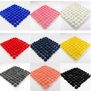 Op de afbeelding: Een set van tien 2,5 cm schuimtufts in verschillende kleuren, waaronder blauw, roze, wit, rood, donkerblauw, geel, grijs, perzik, zwart en wit. De tufts zijn gerangschikt in een rasterpatroon op een witte achtergrond.