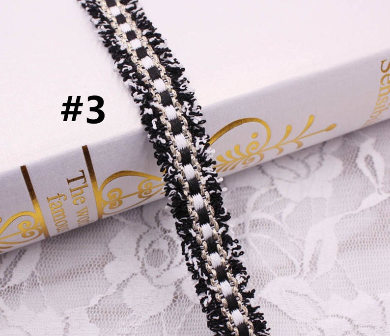 May include: Black and white trim with a silver thread running through it. The trim has a fringe on both sides. #3