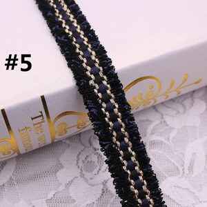 May include: Black and gold trim with a blue fringe. This trim is perfect for adding a touch of elegance to any project.