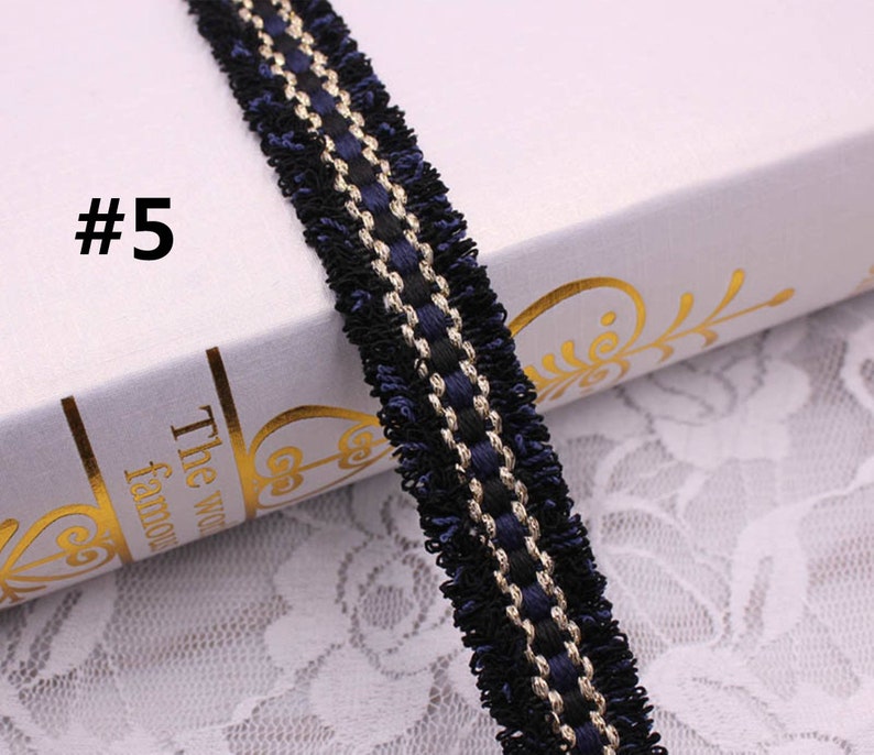 May include: Black and gold trim with a blue fringe. This trim is perfect for adding a touch of elegance to any project.