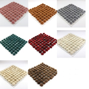 Op de afbeelding: Een set van negen vierkante bases met verschillende gekleurde pluche bosjes. De bases zijn wit en de bosjes zijn roze, bruin, grijs, groen, rood, wit, beige en donkerbruin.