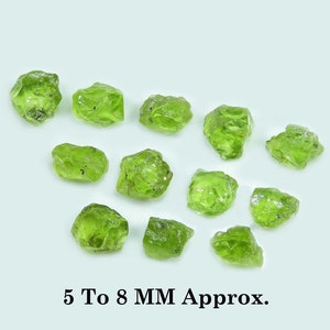 Könnte beinhalten: Eine Sammlung von 12 grünen Peridot-Rohsteinen mit einer Größe von 5 bis 8 mm. Die Steine sind unregelmäßig geformt und haben eine durchscheinende Optik.