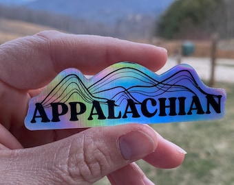 May include: A holographic sticker with a rainbow mountain design and the text "APPALACHIAN" in black.