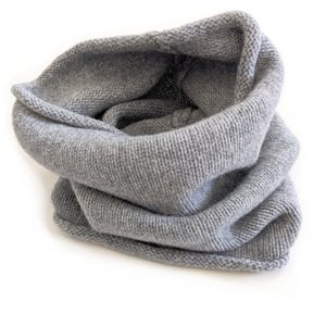 May include: A light gray knitted cowl scarf. The scarf is made of a soft, textured material and is folded over on itself. The cowl is designed to be worn around the neck for warmth and style. The background is white.