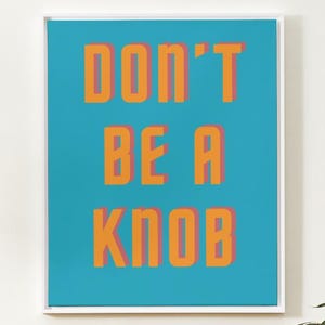 May include: A framed print with a turquoise background and the text "DON'T BE A KNOB" in orange letters with a pink outline.