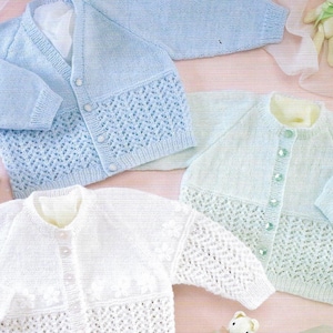 May include: Four knitted baby cardigans in different colors: light blue, white, light green, and yellow. Each cardigan has a button closure and a lacy pattern.