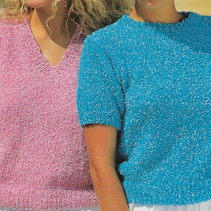 Puede incluir: Dos mujeres con tops de punto peludos. Un top es rosa y sin mangas, el otro es azul con mangas cortas.