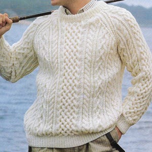 May include: A white cable knit jumper with a crew neck. The jumper features a traditional Irish cable knit pattern.