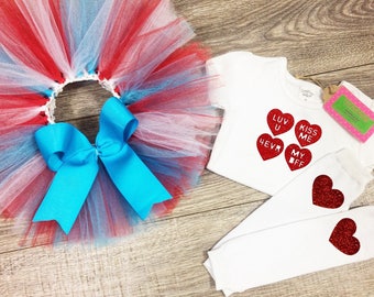 May include: A red, white, and blue tulle tutu with a turquoise bow, a white t-shirt with red glitter hearts that say "Luv U 4evr, Kiss Me, My Bff", and white leg warmers with red glitter hearts.