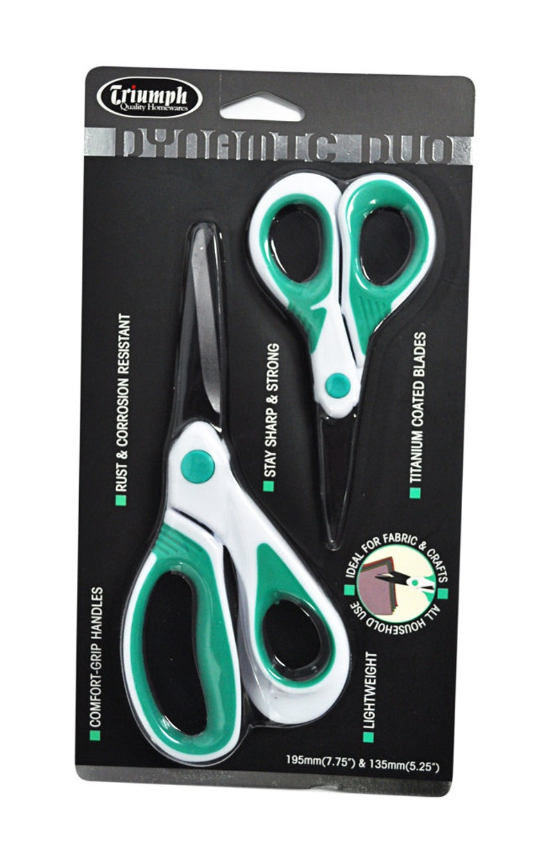 May include: A pair of scissors with white and green handles and titanium coated blades. The scissors are packaged on a black background with the text "Triumph Quality Homewares" and features like "Comfort-Grip Handles", "Rust & Corrosion Resistant", "Stay Sharp & Strong", "Lightweight", "Ideal for Fabric & All Household Use", and "Titanium Coated Blades". The scissors are 7.75 inches and 5.25 inches in length.