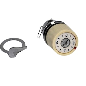 Puede incluir: Un botón de dial de radio vintage con una cara color crema y números negros. El dial tiene una carcasa de metal cromado y un pequeño indicador rojo. También hay un anillo de sintonización de metal cromado separado.