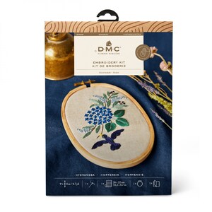 May include: DMC embroidery kit featuring a floral design with blue hydrangeas and a hummingbird. The kit includes a wooden embroidery hoop with a 10.2 x 8.7 inch embroidered piece, along with other supplies. The kit is packaged in a box with the text "EMBROIDERY KIT".