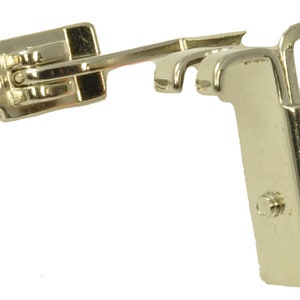 May include: A silver sewing machine foot with an orange plastic roller. The foot has a metal arm that can be adjusted to different angles.