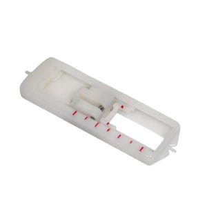 May include: A white plastic sewing machine buttonhole foot with red markings. The foot has a rectangular shape with an open center and a small lever. It is designed to create buttonholes.