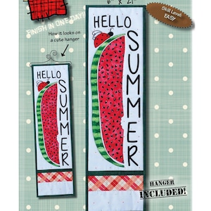 Op de afbeelding: Een quiltpatroon voor een wandhanger met watermeloenmotief. Het patroon toont een watermeloen met een hap eruit en de woorden "Hello Summer" die verticaal zijn geschreven. Het patroon is 15,2 cm bij 53,3 cm en is geclassificeerd als gemakkelijk.