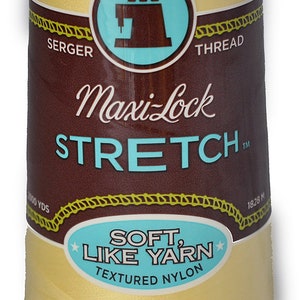 Peut inclure: Une bobine de fil à coudre Maxi-Lock Stretch de couleur jaune pâle. L'étiquette indique "Maxi-Lock Stretch" et "Soft, Like Yarn Textured Nylon".