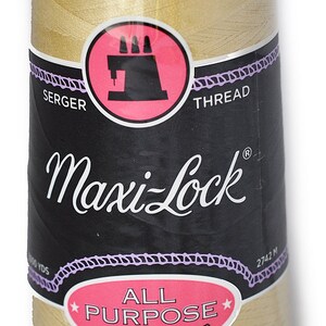 May include: A spool of Maxi-Lock All Purpose Spun Polyester Serger Thread in a light beige color. The spool has a black label with white text that reads "Maxi-Lock" and "All Purpose Spun Polyester".