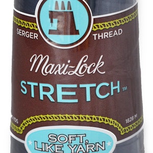 Peut inclure: Une bobine de fil à coudre sergé Maxi-Lock Stretch bleu foncé. L'étiquette indique "Maxi-Lock Stretch" et "Soft, Like Yarn, Textured Nylon". La bobine mesure 1828 mètres de long.