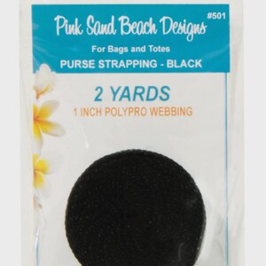 May include: A roll of black polypro webbing for bags and totes, packaged in a clear plastic bag. The label reads Pink Sand Beach Designs #501, 2 YARDS, 1 INCH POLYPRO WEBBING, and PURSE STRAPPING - BLACK, with a floral graphic on the left side.