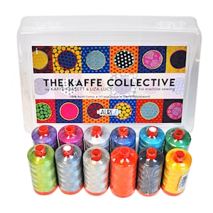 May include: A clear plastic storage case with a colorful label that reads "THE KAFFE COLLECTIVE by KAFFE FASSETT & LIZA LUCY for machine sewing 100% Aurifil Cotton 12 Large Spools 50wt (1422yds/spool)". The case contains 12 spools of colorful thread.