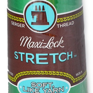 Peut inclure: Une bobine de fil à coudre Maxi-Lock Stretch de couleur verte avec le texte "Soft Like Yarn" et "Textured Nylon".