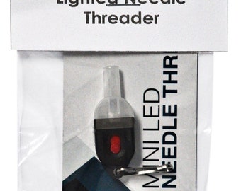 May include: A white and black package containing a small, black, battery-powered LED needle threader. The threader has a red button and a clear plastic tip. The package includes the text "MINI LED NEEDLE THR" and "BRIGHT WHITE LED BATTERIES INCLUDED".