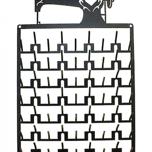 May include: Black metal sewing thread organiser with a silhouette of a sewing machine at the top. The organiser has 40 slots for spools of thread.