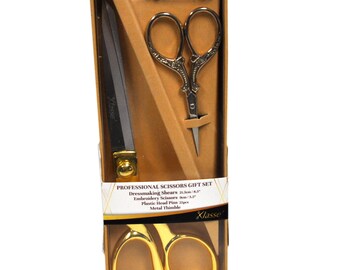 May include: A gift set of gold-toned sewing scissors in a clear plastic box with a brown cardboard backing. The set includes a pair of dressmaking shears, a pair of embroidery scissors, a thimble, and 25 plastic head pins. The box has the text "Professional Scissors Gift Set" and "Klasse" printed on it.