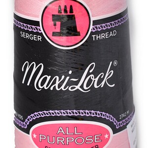 Könnte beinhalten: Eine rosa Spule Maxi-Lock Allzweck-Garn aus Spinnpolyester für Overlockmaschinen. Die Spule ist mit dem Markennamen und der Garnart beschriftet.