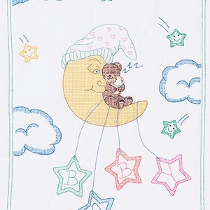 Puede incluir: Un patrón de punto de cruz con un oso de peluche durmiendo con un gorro rosa y blanco en una luna creciente amarilla. La luna cuelga de un móvil con cuatro estrellas que deletrean "BABY". Las estrellas son verdes, rojas, rosas y azules. El fondo es blanco con nubes azules y estrellas amarillas.