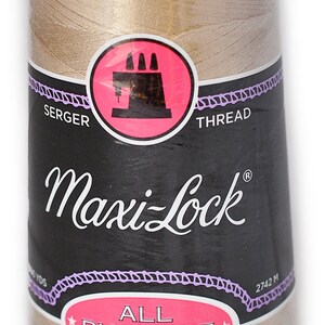 Op de afbeelding: Een spoel Maxi-Lock All Purpose Spun Polyester Overlockgaren in beige kleur. De spoel is gelabeld met de merknaam "Maxi-Lock" en de tekst "Overlockgaren".