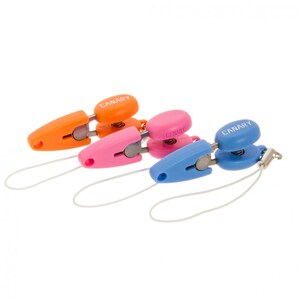 Op de afbeelding: Drie kleurrijke telefooncharms met een veerbelaste clip en een koord. De charms zijn oranje, roze en blauw en elk heeft het woord "CANARY" erop gedrukt.