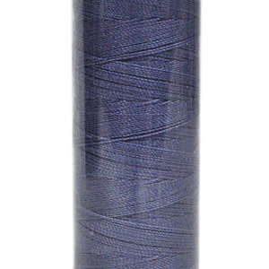 May include: A spool of dark blue denim thread, labeled "DENIM DOC Art. 5100." The thread is tightly wound around a cylindrical core. The bottom of the spool has the text "col.3624 H75T3."
