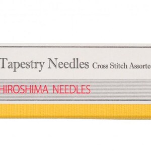 May include: A yellow package of tapestry needles with the text "Tapestry Needles Cross Stitch Assorted" and "Hiroshima Needles". The package has a red string and a white tag with a logo. The needles are made in Japan.
