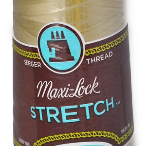 Peut inclure: Une bobine de fil à coudre sergé Maxi-Lock Stretch de couleur or, étiquetée "Soft, Like Yarn" et "Textured Nylon". Elle mesure 2000 yards (1828 mètres).