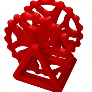 May include: A red 3D printed model of a Ferris wheel with a triangular base.