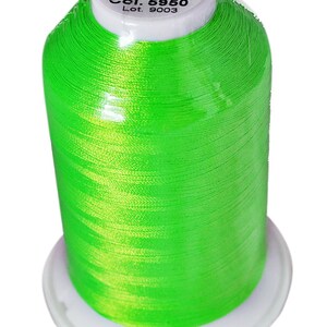 May include: A spool of bright green thread, labeled "RHEINGOLD Mr.40 Germany 5000m 100% Polyester filament Art. Nr. P914 Col. 5950 Lot. 9003"