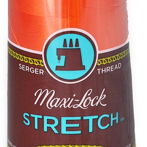 Peut inclure: Une bobine de fil à coudre orange Maxi-Lock Stretch pour surjeteuse. L'étiquette indique "Maxi-Lock Stretch" et "Doux, comme du fil, Nylon texturé".