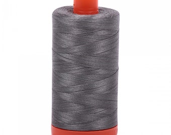 Puede incluir: Una bobina de hilo de coser gris con una bobina de plástico naranja.