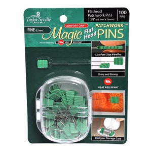 May include: A package of 100 green flathead patchwork pins with comfort grip handles. The pins are heat resistant and come in a designer storage case. The package says "Magic Flat Head Pins" and "Comfort Grip".