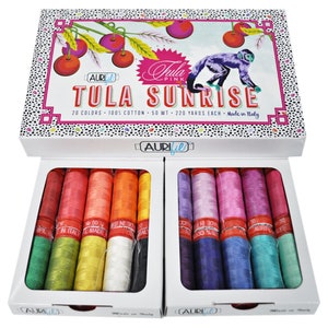 May include: A box of 20 spools of Aurifil thread in a variety of colors. The box is labeled "Tula Pink" and "Tula Sunrise". The spools are 50 weight and 220 yards each. The thread is 100% cotton and made in Italy.
