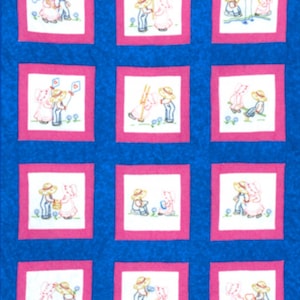 May include: A blue quilted fabric with pink squares. Each square contains an embroidered image of two figures in various activities, such as holding an umbrella, flying a kite, and holding a rake.